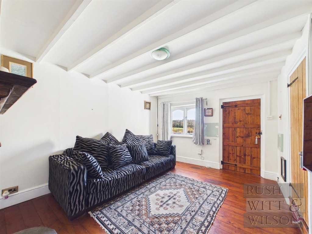Lot: 123 - SEMI-DETACHED COTTAGE FOR REFURBISHMENT WITH FAR REACHING VIEWS - View of living room with front door showing